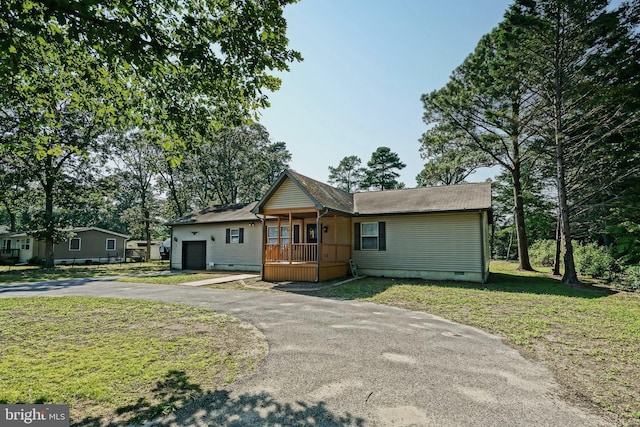 view of front of property with a front yard, a garage, and a porch