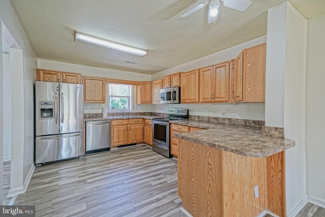 kitchen with light hardwood / wood-style floors, sink, appliances with stainless steel finishes, and ceiling fan