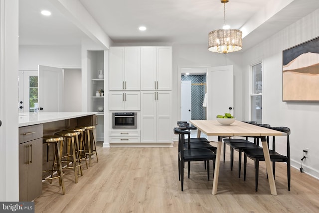 dining space with an inviting chandelier and light wood-type flooring