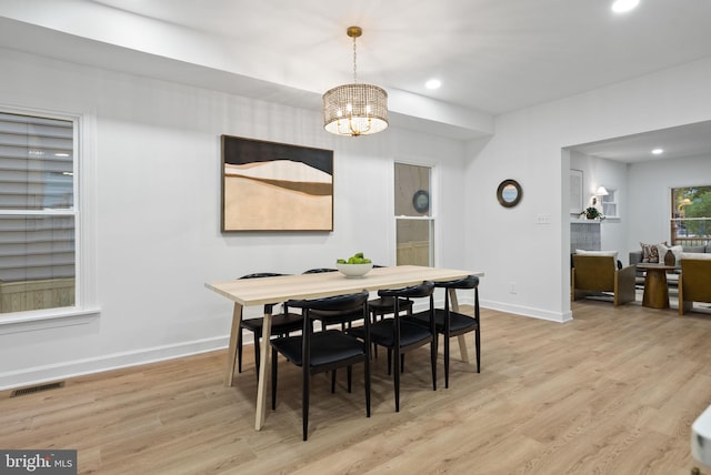 dining room featuring an inviting chandelier and light wood-type flooring