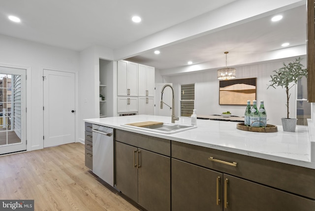 kitchen with stainless steel dishwasher, white cabinets, pendant lighting, sink, and light hardwood / wood-style floors