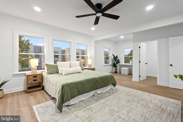 bedroom with multiple windows, light wood-type flooring, and ceiling fan