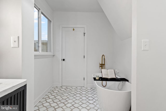 bathroom featuring vanity, tile patterned floors, and lofted ceiling