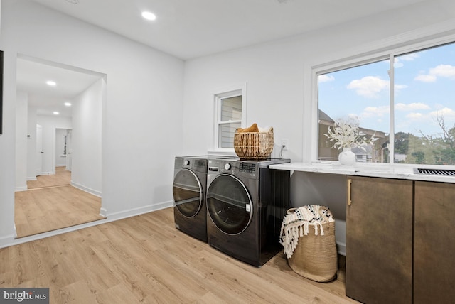 laundry area with washer and clothes dryer and light wood-type flooring