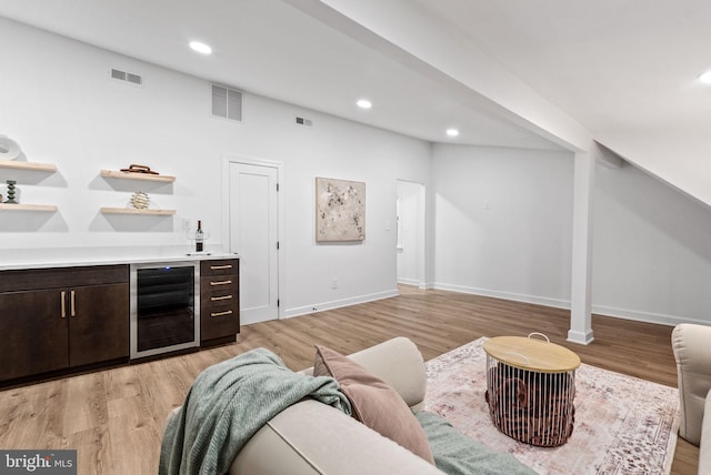 living room with indoor bar, light wood-type flooring, and wine cooler