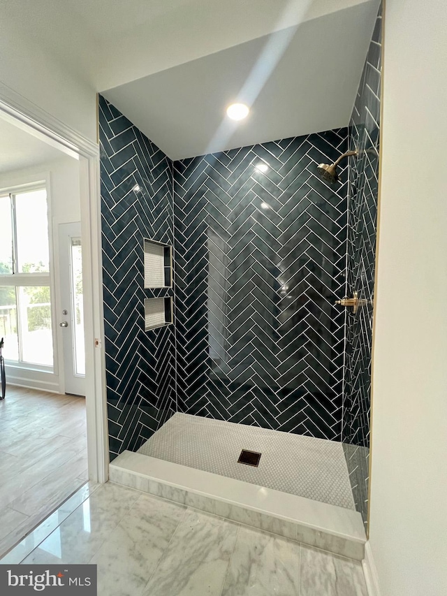 bathroom with tiled shower and tile patterned floors