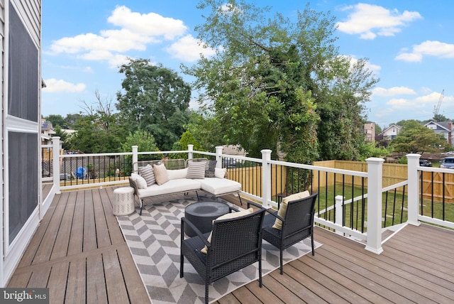 wooden terrace with an outdoor hangout area and a lawn