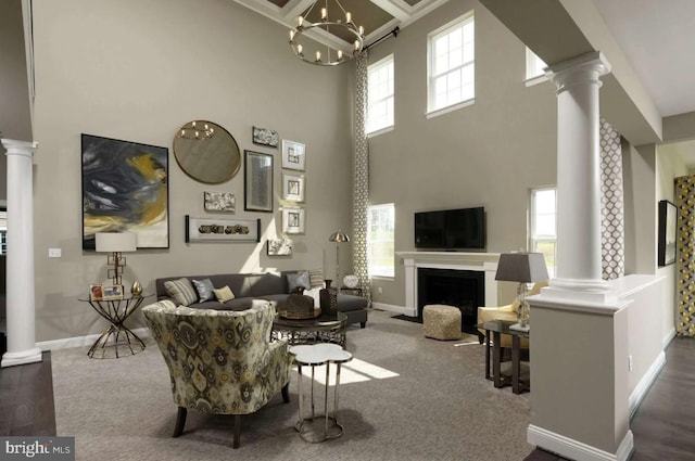 living room with an inviting chandelier, a healthy amount of sunlight, and a high ceiling