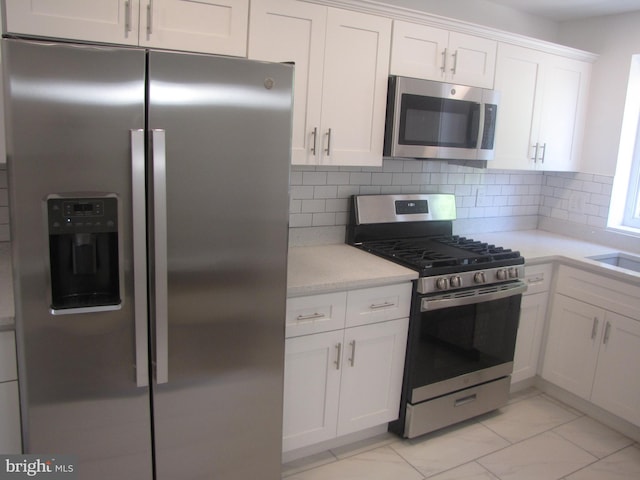 kitchen featuring backsplash, white cabinetry, and stainless steel appliances