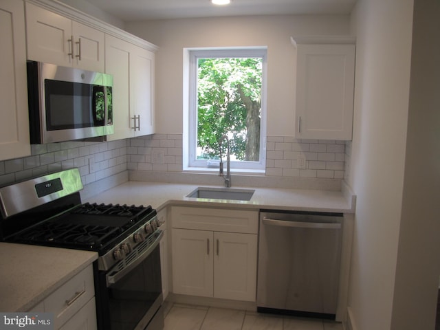 kitchen featuring white cabinets, backsplash, sink, and stainless steel appliances