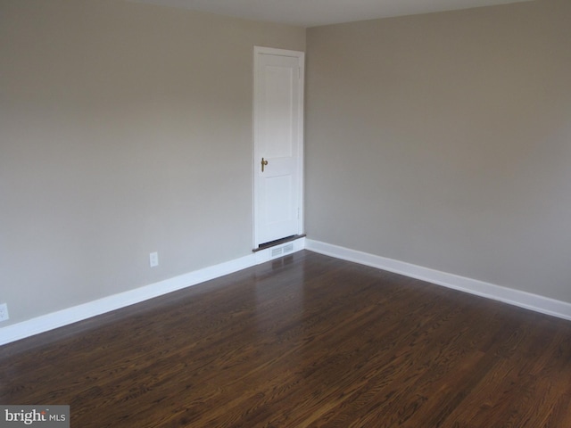 spare room featuring dark wood-type flooring