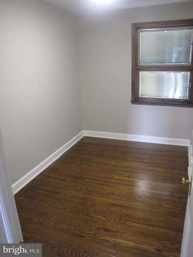 unfurnished room featuring dark wood-type flooring