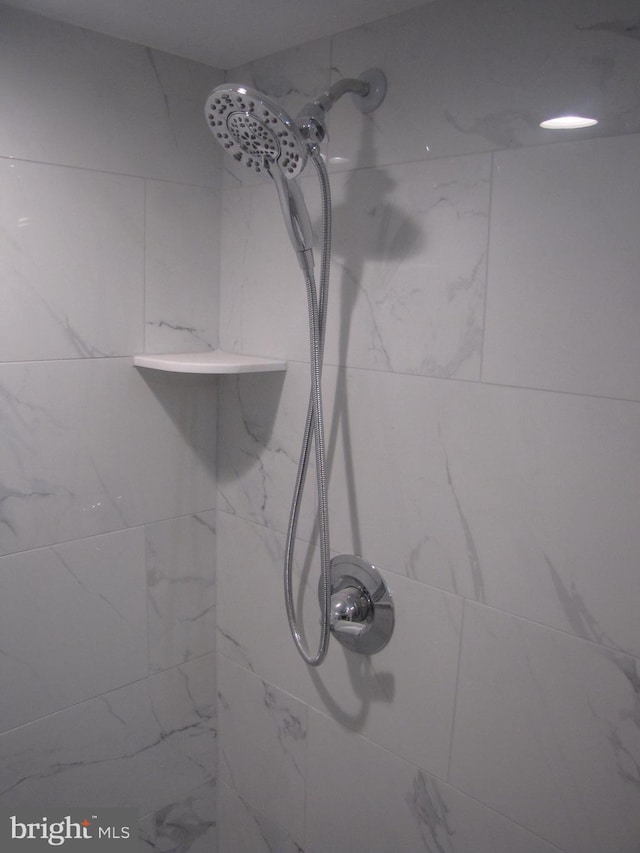 interior details featuring tiled shower