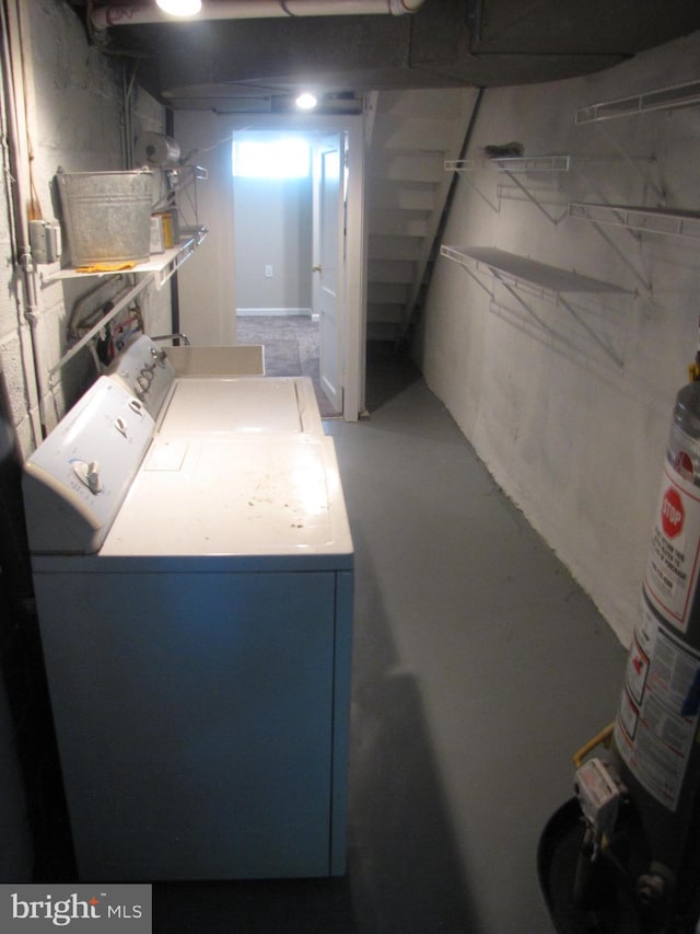 basement featuring gas water heater and washing machine and clothes dryer