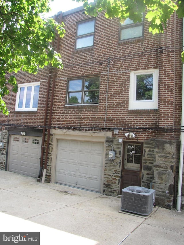 view of front of home featuring a garage and central air condition unit