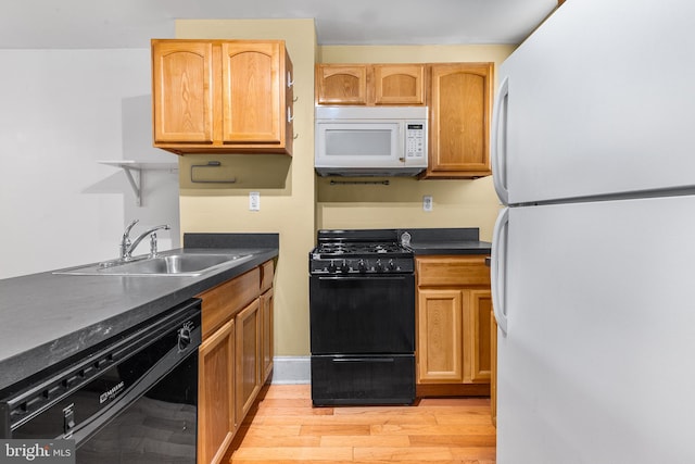 kitchen featuring sink, light hardwood / wood-style flooring, and black appliances