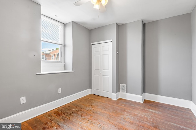 unfurnished bedroom with ceiling fan, a closet, and light hardwood / wood-style flooring