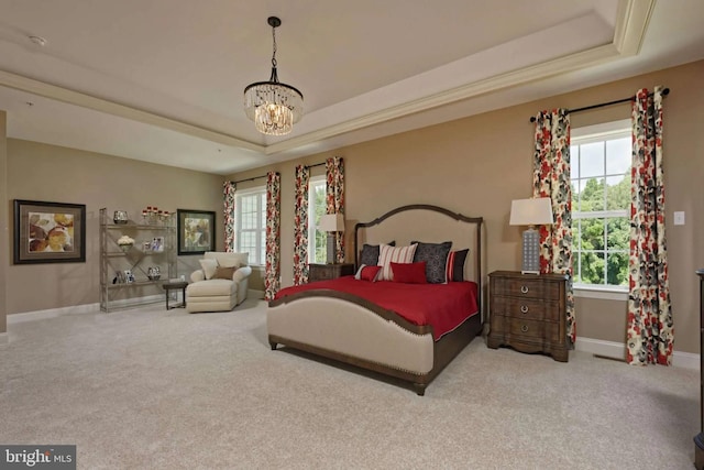 carpeted bedroom featuring multiple windows, a tray ceiling, and a notable chandelier