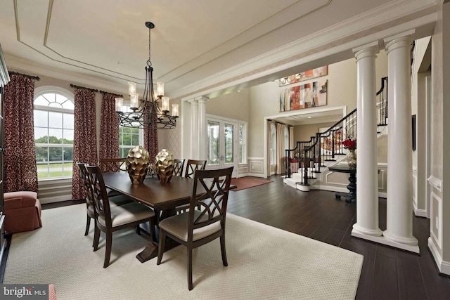 dining room with dark wood-type flooring, an inviting chandelier, and ornamental molding