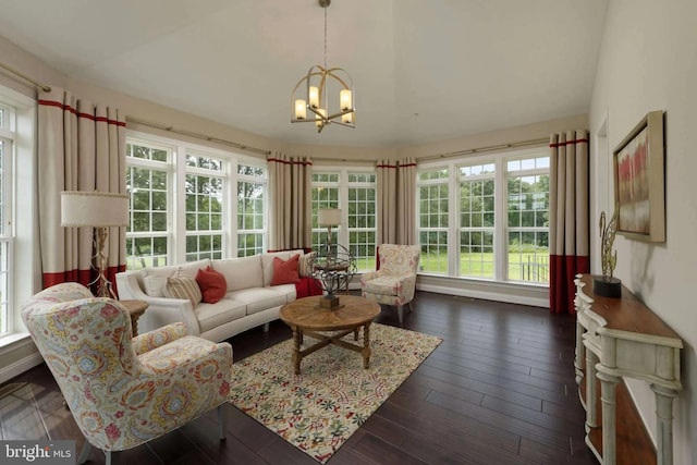 living room with plenty of natural light, dark hardwood / wood-style flooring, and a notable chandelier