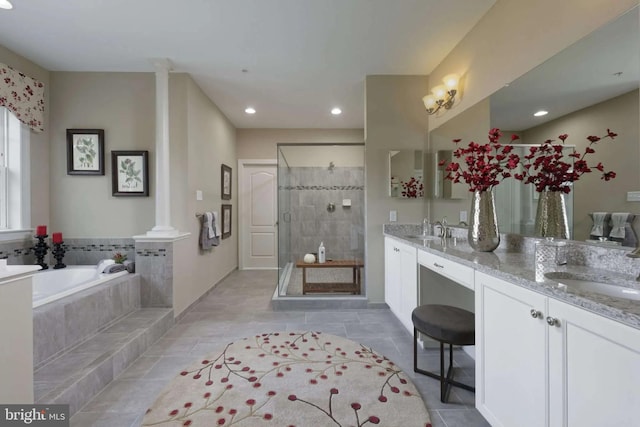 bathroom with separate shower and tub, vanity, and ornate columns