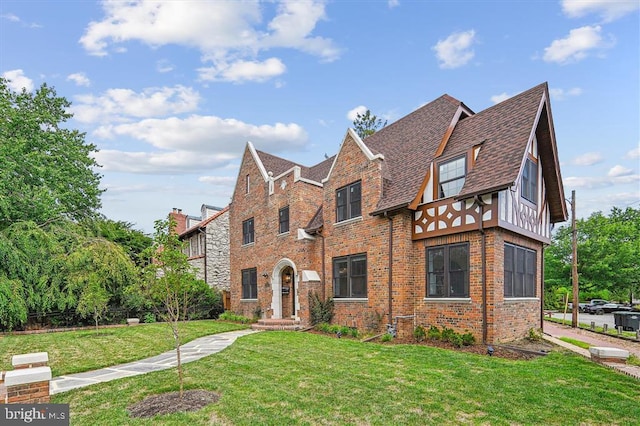 english style home featuring a front yard