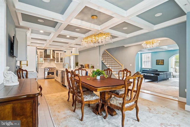 dining space featuring light hardwood / wood-style floors, a chandelier, and coffered ceiling