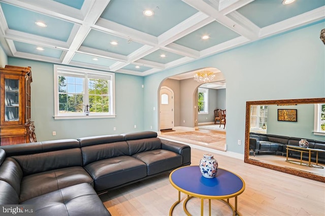 living room featuring hardwood / wood-style flooring, beamed ceiling, a notable chandelier, and coffered ceiling