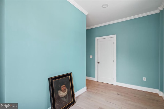 empty room featuring crown molding and light hardwood / wood-style floors