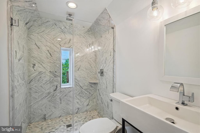 bathroom featuring toilet, a shower with shower door, and sink