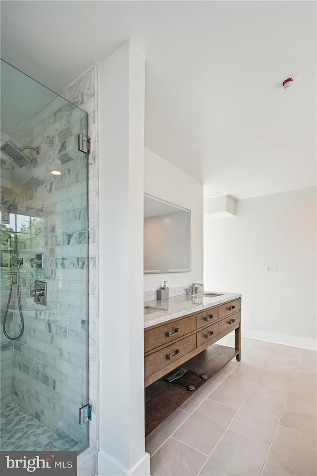 bathroom with an enclosed shower, vanity, and tile patterned flooring