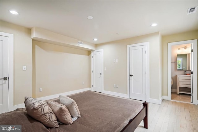 bedroom featuring ensuite bathroom and light hardwood / wood-style flooring