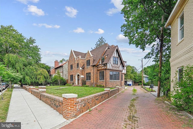 tudor home with a front lawn