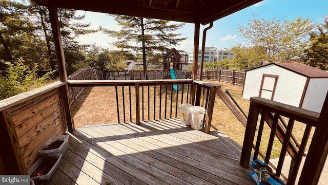 deck with a playground and a storage unit