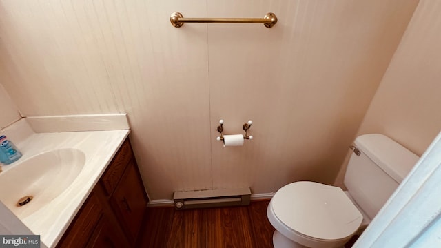 bathroom featuring baseboard heating, hardwood / wood-style flooring, vanity, and toilet