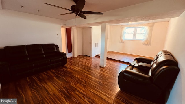 living room featuring ceiling fan and dark wood-type flooring