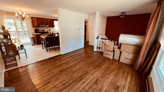 living room featuring a baseboard radiator, a notable chandelier, and dark wood-type flooring