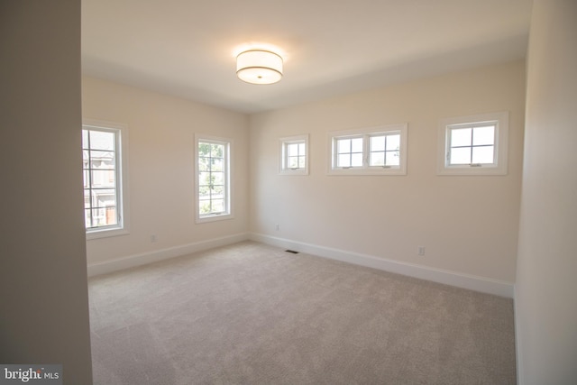 unfurnished room featuring light carpet