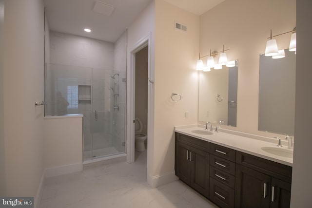 bathroom with vanity, a shower with shower door, and toilet