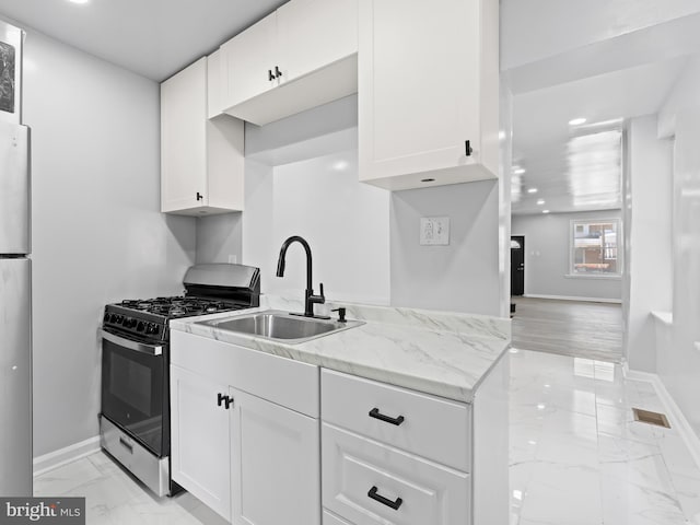 kitchen featuring sink, white cabinets, and appliances with stainless steel finishes