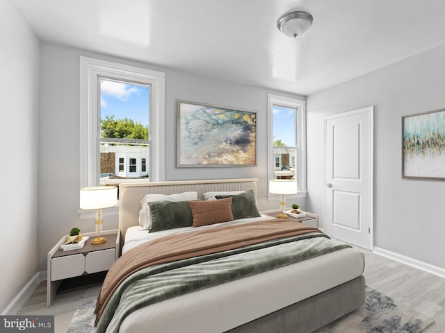 bedroom with multiple windows and wood-type flooring