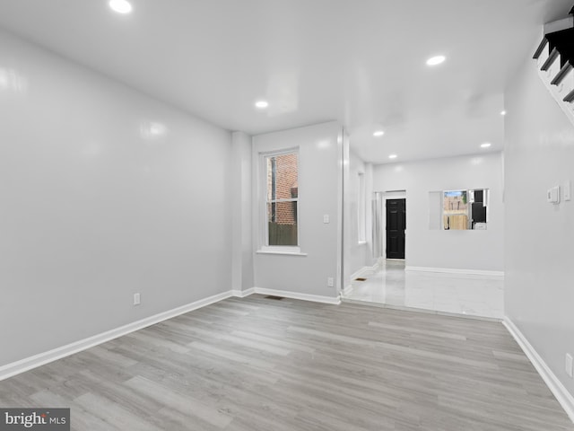 unfurnished living room featuring plenty of natural light and light hardwood / wood-style flooring