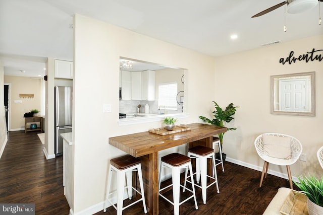 dining space with sink, dark hardwood / wood-style flooring, and ceiling fan