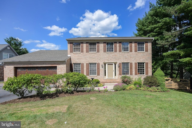 colonial home featuring a garage and a front lawn