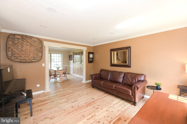 living room with crown molding, ornate columns, and light hardwood / wood-style flooring