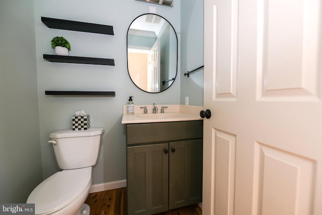 bathroom featuring toilet, vanity, and hardwood / wood-style floors