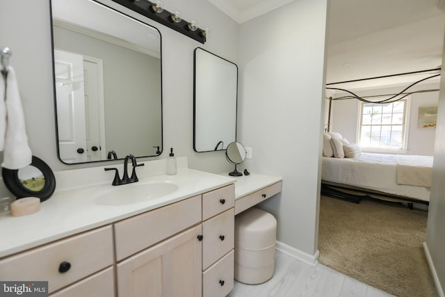 bathroom with ornamental molding, hardwood / wood-style flooring, and vanity