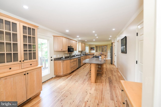 kitchen with a kitchen island, light hardwood / wood-style flooring, appliances with stainless steel finishes, light brown cabinets, and ornamental molding