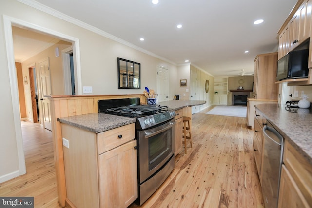 kitchen featuring crown molding, light wood-type flooring, appliances with stainless steel finishes, and light brown cabinets