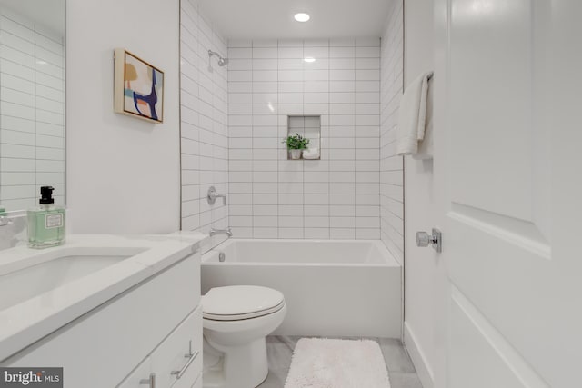 full bathroom with vanity, tiled shower / bath, tile patterned flooring, and toilet